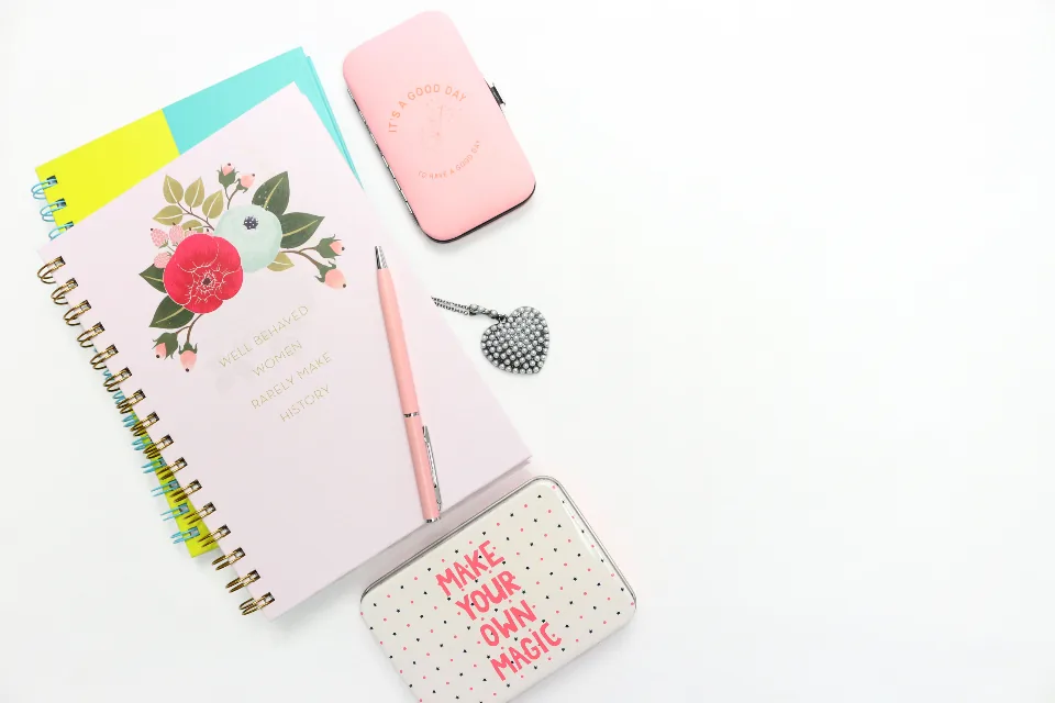 A pink floral planner, a pen and a card that says make your own magic, laid out for a 5x55 writing session