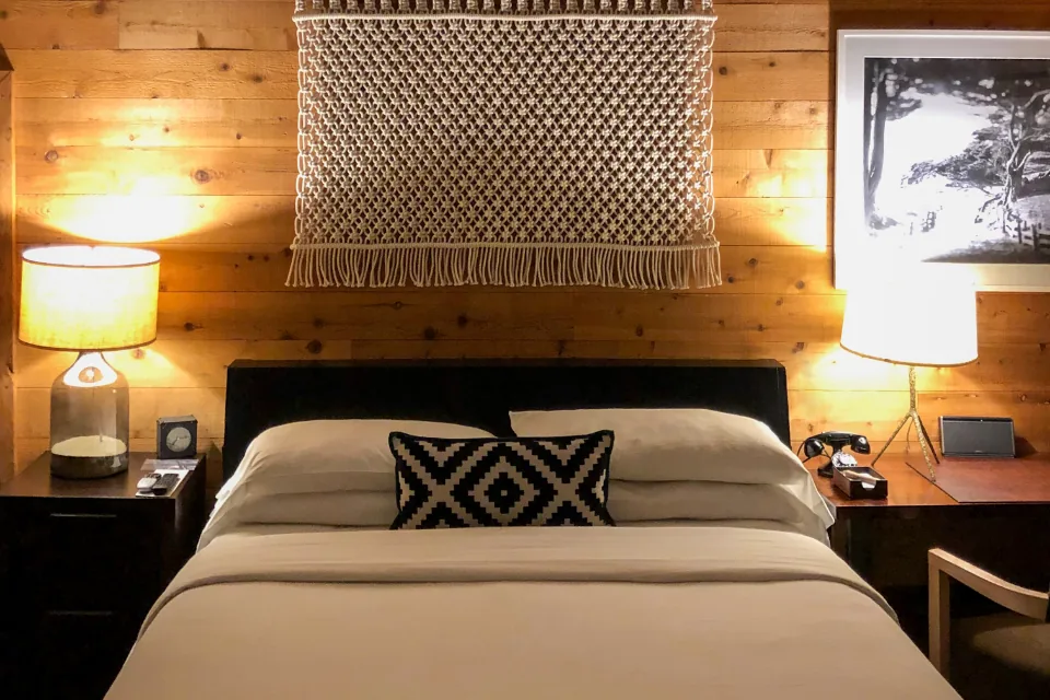 A cosy bedroom at night with warm bedside lamps and a neatly made bed